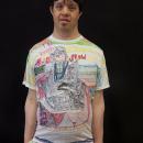 The artist, Pablo Rahner, a latino man, wearing his art t-shirt with a Rocky Horror design on it